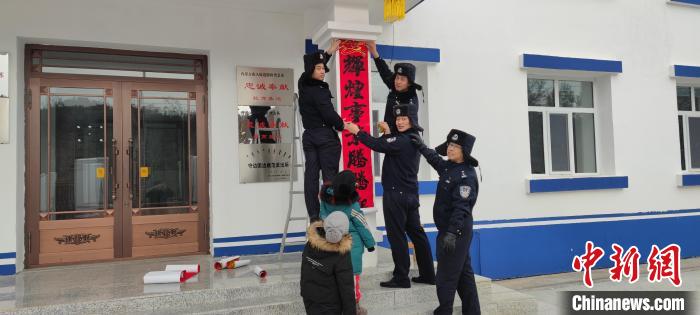圖為恩和哈達(dá)邊境派出所民警貼對(duì)聯(lián)?！《骱凸_(dá)邊境派出所供圖